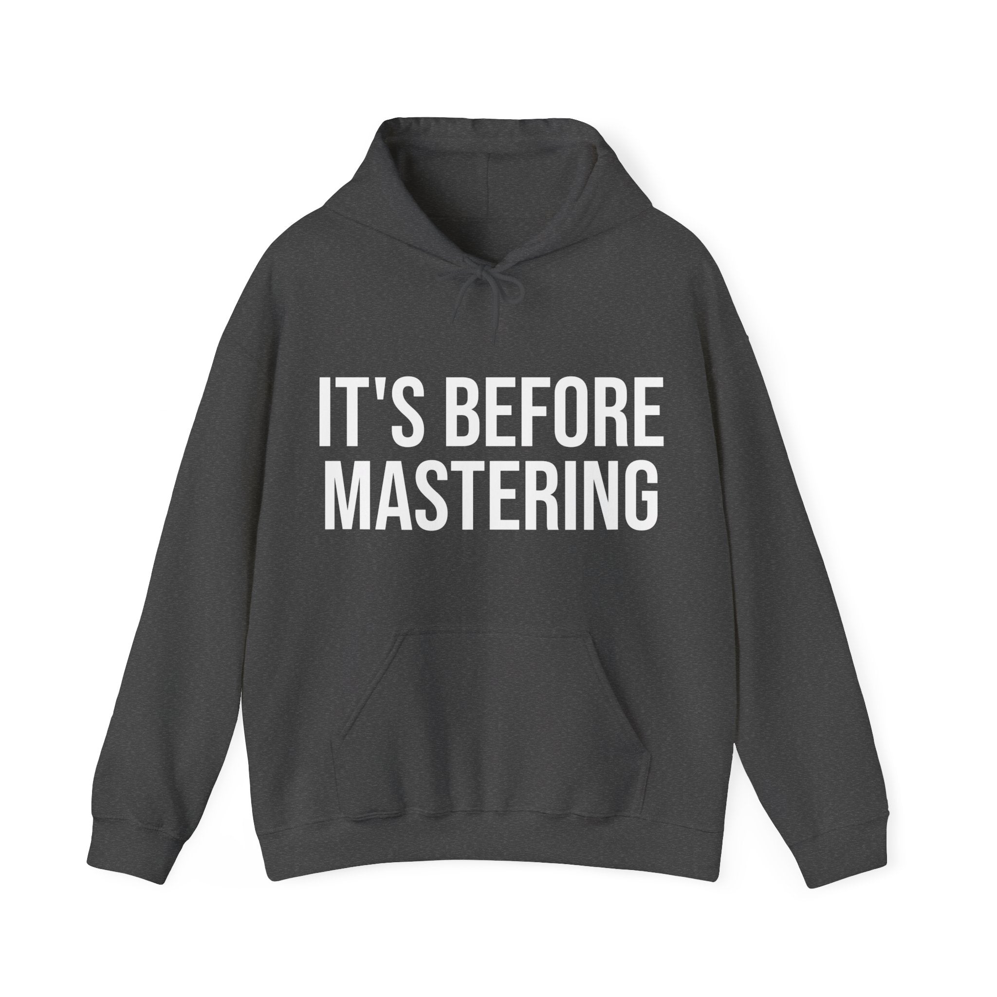 A heather brown hooded sweatshirt with a drawstring hood and a kangaroo pocket is laid out flat. Emblazoned across the chest in bold, block letters is the statement 'IT'S BEFORE MASTERING,' implying a stage in the audio production process before a track is fully produced. The typography and message resonate with music producers and audio engineers who appreciate the steps of music creation